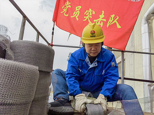 5月10日中午，在動(dòng)力車(chē)間三期工藝除氧器平臺(tái)上，黨員突擊隊(duì)隊(duì)長(zhǎng)李鑫正在纏繞新填料.jpg
