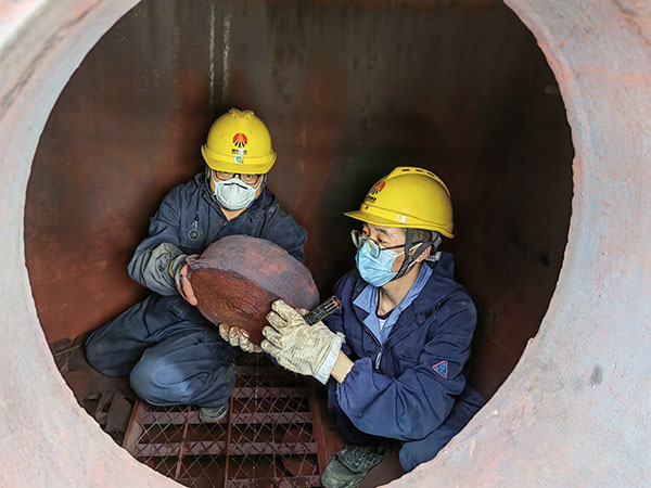 5月11日，動力車間三期工藝除氧器內(nèi)部，黨員突擊隊隊員劉瑞斌和李震正在清理舊填料.jpg